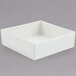 A white square Bon Chef bowl with a sandstone finish on a grey surface.
