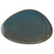 An oval blue Oneida Terra Verde Dusk porcelain serving platter with brown specks on the table.