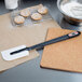 A Matfer Bourgeat spatula with a cookie on it over a bowl of flour.