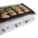 A Cooking Performance Group gas charbroiler with meat and vegetables cooking on it.