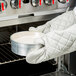 A person in white gloves using a Chicago Metallic springform cake pan to bake a cake.