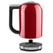 A red and stainless steel KitchenAid electric kettle.
