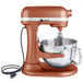 A brown KitchenAid stand mixer with a copper bowl.