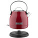 A red KitchenAid electric kettle with a black base and handle.