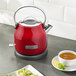 A red KitchenAid electric kettle on a counter.