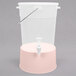 A translucent plastic beverage dispenser with a pink base and white lid.