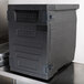 A black plastic Cambro Cam GoBox front loader door on a metal surface.