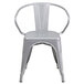 A silver metal outdoor restaurant chair with arms and a slat back.