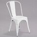 A white metal Flash Furniture outdoor restaurant chair with a slat back and drain hole seat.