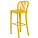 A yellow Flash Furniture metal bar stool with a backrest.