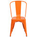 An orange Flash Furniture metal chair with a slatted back and drain hole seat.