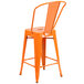 An orange metal outdoor restaurant bar stool with a backrest.