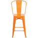 An orange metal counter height stool with a vertical slat back and drain hole seat.