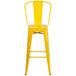 A Flash Furniture yellow galvanized steel bar stool with backrest and drain hole seat.