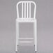 A white metal Flash Furniture counter height stool with a vertical slat back.
