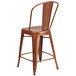 A copper metal outdoor restaurant bar stool with a backrest.