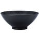 A black porcelain pedestal bowl with a textured pattern on it.