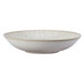 A white Oneida Knit porcelain low bowl with speckled spots.