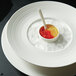 A white Oneida porcelain rim soup bowl with food and a spoon.