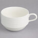A stack of Oneida warm white porcelain cups with a handle on a white surface.