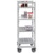 A white Cambro Camshelving Premium mobile unit with vented shelves holding plastic containers of food.