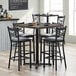 A Lancaster Table & Seating espresso finish butcher block table with chairs around it.