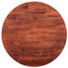 A Lancaster Table & Seating round wood table top with a mahogany finish.