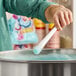 A person holding a white cotton candy cone while making blue cotton candy.