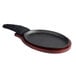 A black oval cast iron fajita skillet with a wooden underliner and handle.