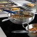 A Vollrath Mirage Induction Warmer with a black ceramic template holding pans of food.