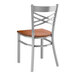 A Lancaster Table & Seating metal cross back chair with a wooden seat and back.
