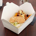 A croissant sandwich in a white Fold-Pak Bio-Pak take-out box.