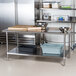 An Advance Tabco stainless steel kitchen work table with an undershelf.