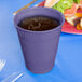 A purple Creative Converting plastic cup with a drink in it.