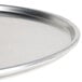 A close-up of an American Metalcraft silver aluminum pizza pan with a white surface.