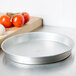 An American Metalcraft tin-plated steel deep dish pizza pan on a counter.