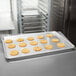 A Vollrath Wear-Ever bun sheet pan with cookies on a counter.