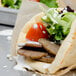 A pita sandwich filled with Kronos Beef and Lamb Gyros slices, lettuce, tomatoes, and cheese.