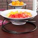 A bowl of oranges on an American Metalcraft wrought iron riser.