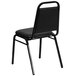 A Flash Furniture black vinyl banquet chair with black metal legs.