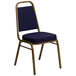 A navy blue banquet chair with a blue and gold patterned seat and gold frame.