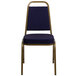 A Flash Furniture Hercules navy blue fabric banquet chair with a gold frame and a navy blue seat.