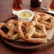 A plate of Dutch Country Foods gluten-free soft pretzels with dipping sauces.