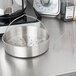 A Monix stainless steel pot with a strainer on top.