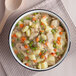A bowl of Spring Glen Fresh Foods chicken stew with a wooden spoon.