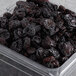 A plastic container full of dried sweet cherries.