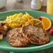 A white plate with Hatfield Chef Signature Pork Sausage Patties, eggs, and oranges.