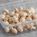 A clear plastic container filled with Fresh Button Mushrooms.
