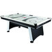 An Atomic air hockey table with a white and black surface.