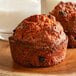 Two Bake'n Joy raisin bran muffins on a wood plate.